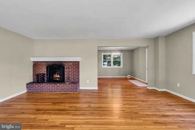 a view of empty room with wooden floor and fireplace