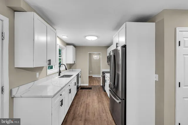 a kitchen with a refrigerator sink and cabinets