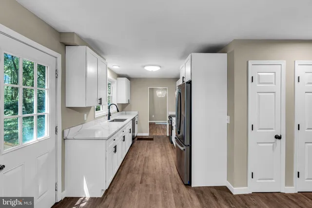 a view of a hallway with wooden floor and staircase