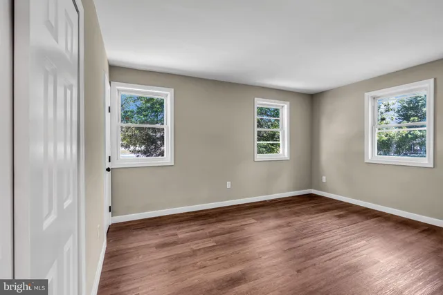 a view of a room with wooden floor and windows