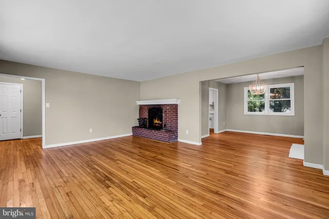 a view of empty room with wooden floor and fireplace