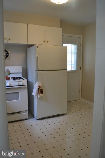 12702 Feldon Street Silver Spring, MD 20906 - Photo 11 of 11 a kitchen with a refrigerator and white cabinets