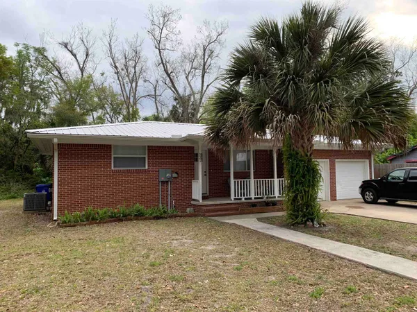a house that has a tree in front of it