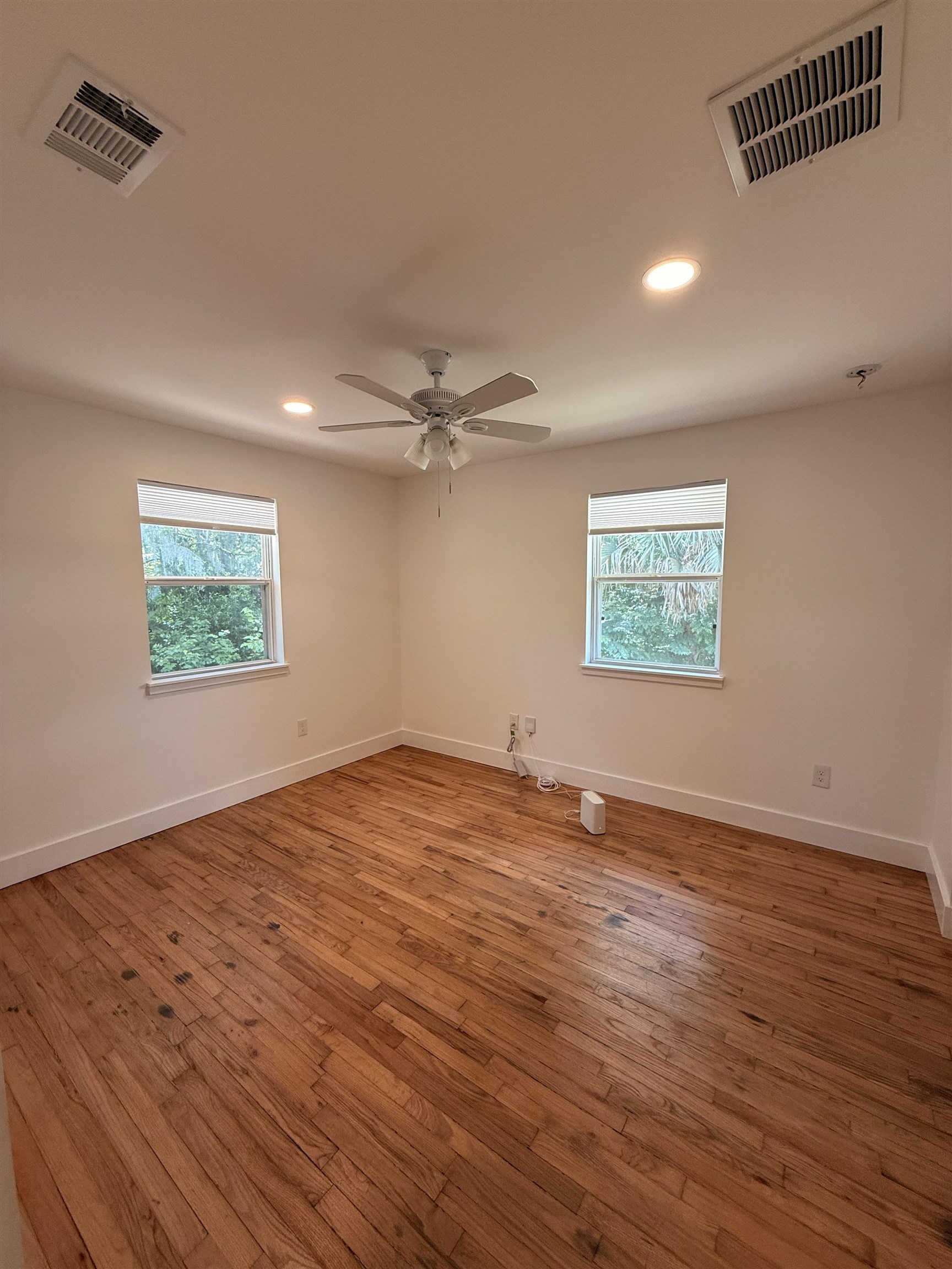 521 Christopher Street St. Augustine, FL 32084 - Photo 12 of 17 an empty room with wooden floor ceiling fan and windows