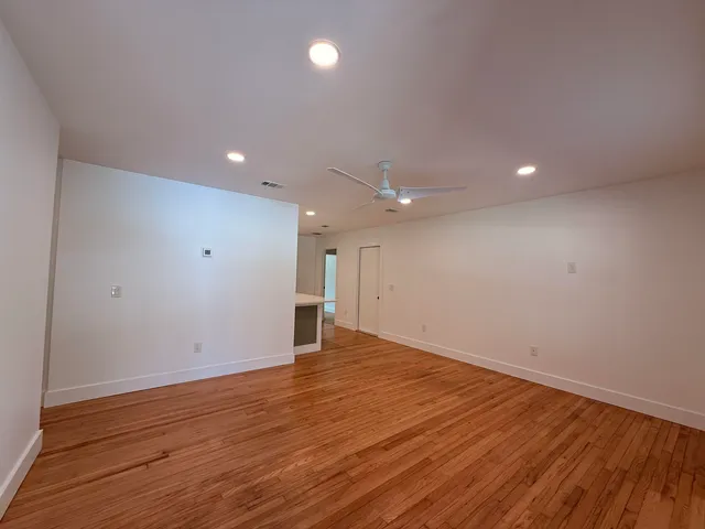 a view of an empty room with wooden floor