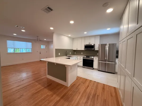 a kitchen with stainless steel appliances a refrigerator sink and microwave