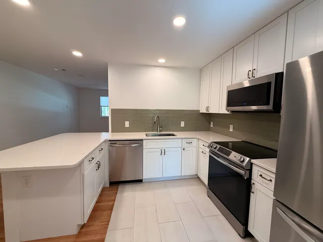 a kitchen with a sink stove and microwave