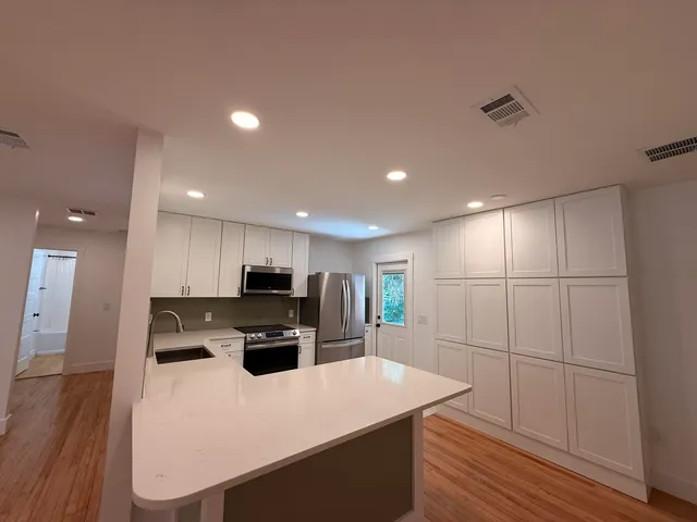 a kitchen with kitchen island a stove a microwave a sink and a refrigerator