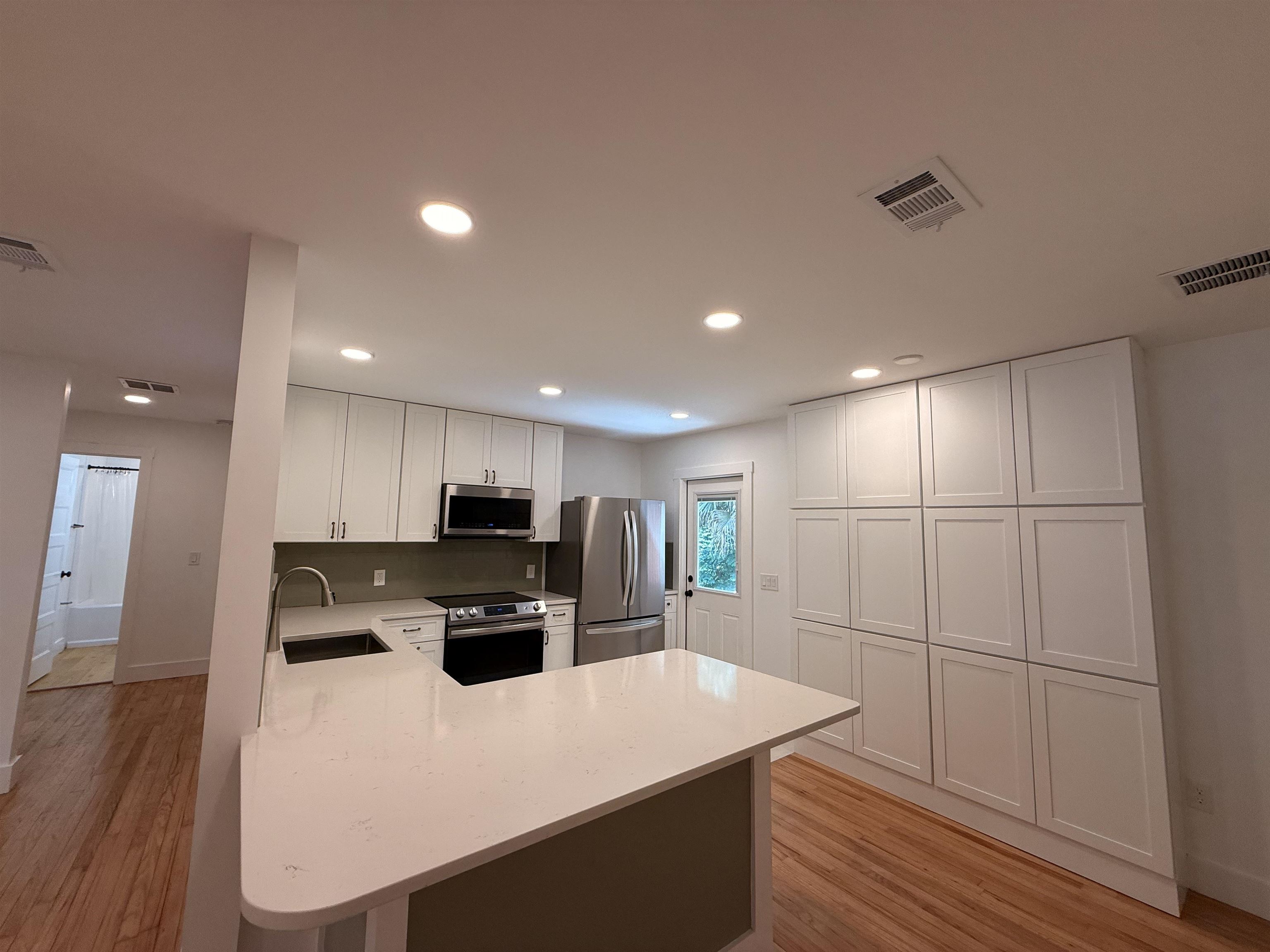 521 Christopher Street St. Augustine, FL 32084 - Photo 6 of 17 a kitchen with kitchen island a stove a microwave a sink and a refrigerator
