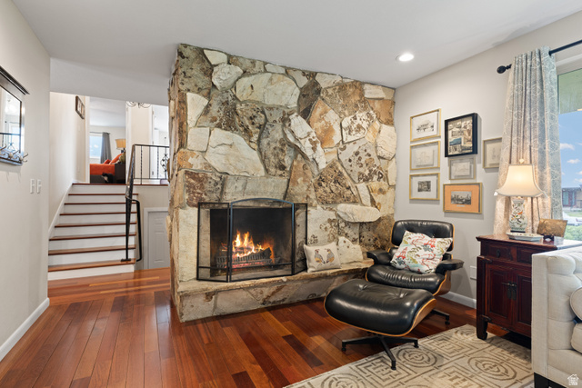 3320 Cherokee Lane Provo, UT 84604 - Photo 6 of 52 Living area featuring a stone-clad fireplace with a metal screen, wood-finish flooring, and recessed lighting