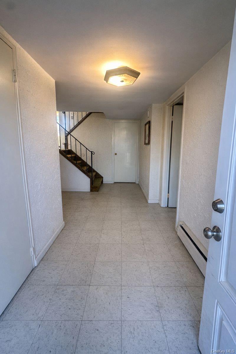 106 Burton Lane Commack, NY 11725 - Photo 2 of 2 an empty room with a space and windows