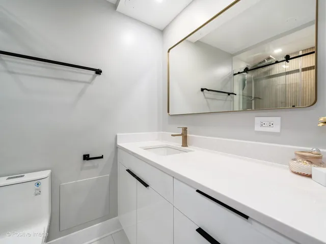 a bathroom with a sink a toilet and mirror