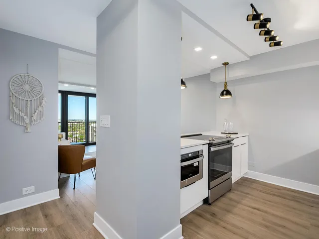 a kitchen with wooden floor and stainless steel appliances
