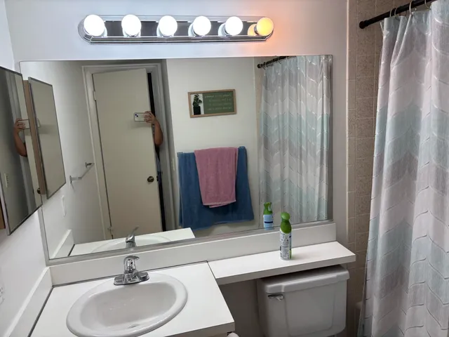 a bathroom with a granite countertop sink and a mirror