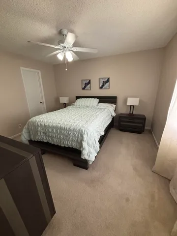 a bedroom with a bed and ceiling fan
