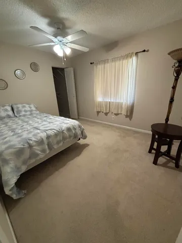 a spacious bedroom with a bed and a chandelier