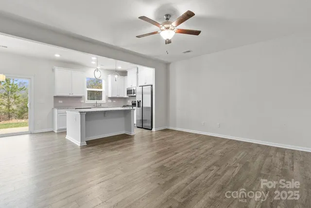 a view of kitchen with granite countertop cabinets and window