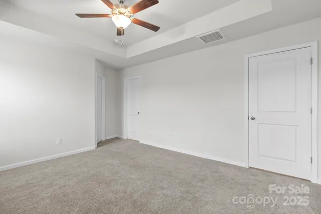 an empty room with ceiling fan and window