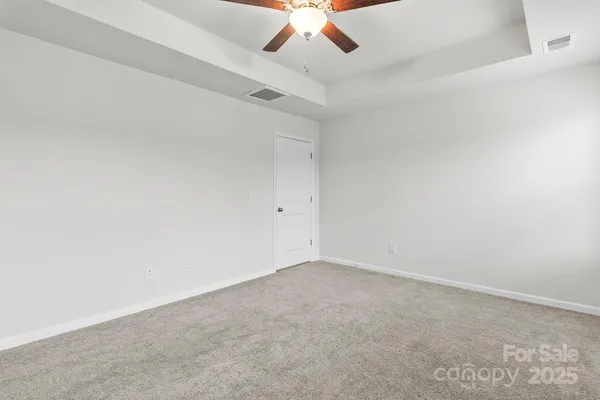 an empty room with a chandelier fan