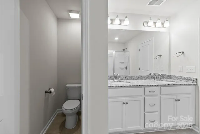 a bathroom with a granite countertop sink a toilet and a mirror