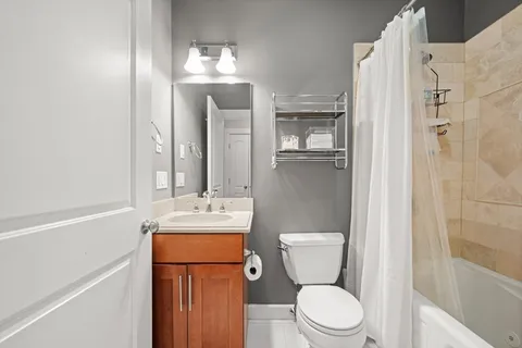 a bathroom with a toilet sink vanity and shower