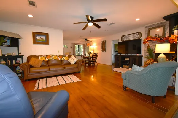 a living room with furniture and a flat screen tv with wooden floor