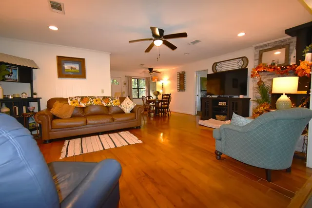 a living room with furniture and a flat screen tv with wooden floor