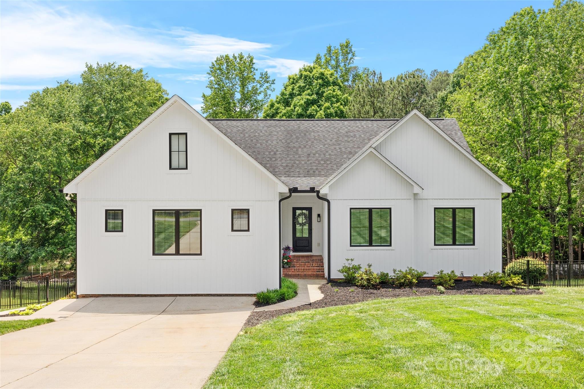 184 Quiet Cove Road Mooresville, NC 28117 - Photo 1 of 45 a view of a white house next to a yard with plants and trees
