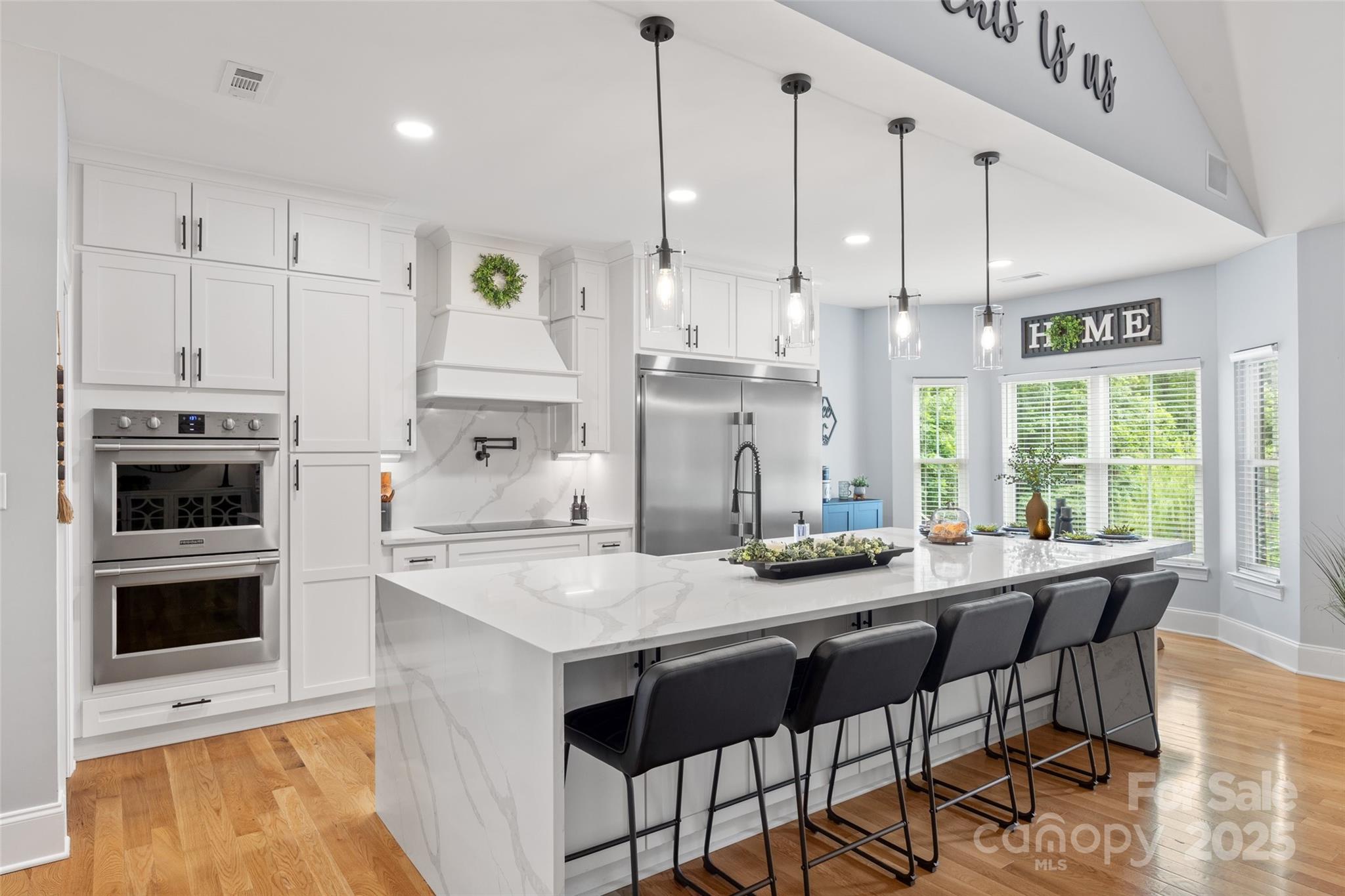 184 Quiet Cove Road Mooresville, NC 28117 - Photo 6 of 45 a kitchen with stainless steel appliances granite countertop a stove a sink a microwave a dining table and chairs
