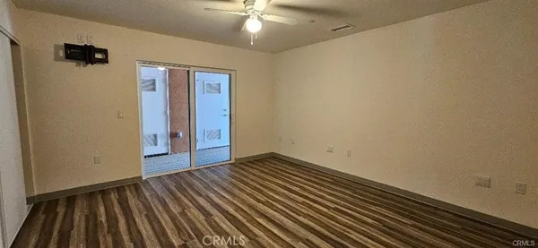 a view of an empty room with wooden floor