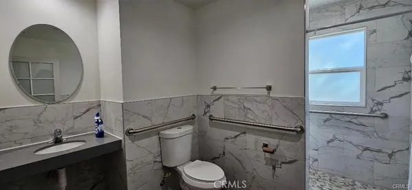 a bathroom with a granite countertop toilet sink and mirror