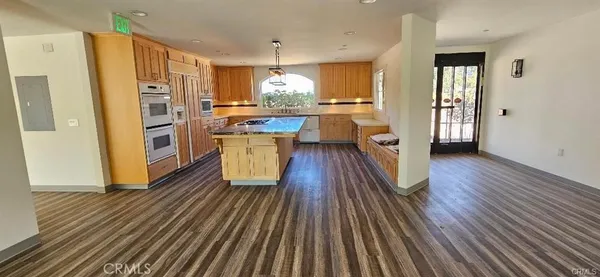 a kitchen with stainless steel appliances a refrigerator a sink dishwasher and a stove with wooden floor