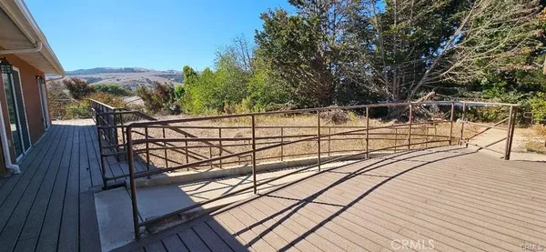 a view of balcony with wooden floor and fence