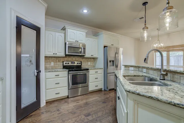 a kitchen with stainless steel appliances granite countertop a sink stove and refrigerator