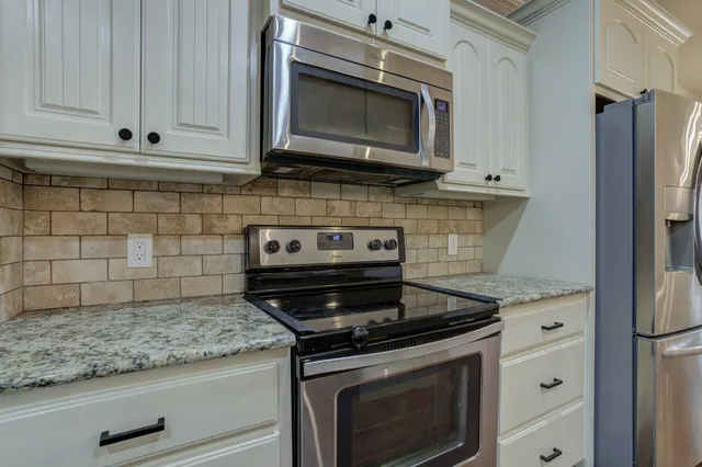 a kitchen with granite countertop cabinets and steel stainless steel appliances