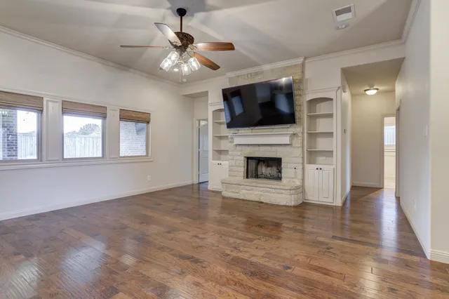 a view of an empty room with a fireplace and a window