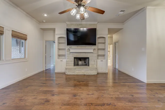 a view of an empty room with a fireplace and a flat screen tv