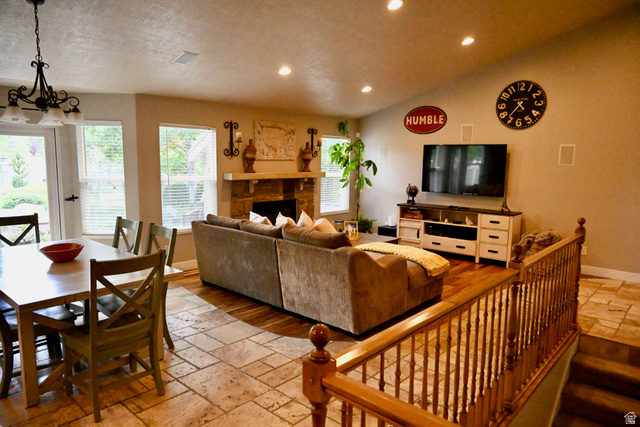 314 Brown Farm Lane Draper, UT 84020 - Photo 9 of 57 Open-concept living space with a stone-clad fireplace and wood-finish flooring