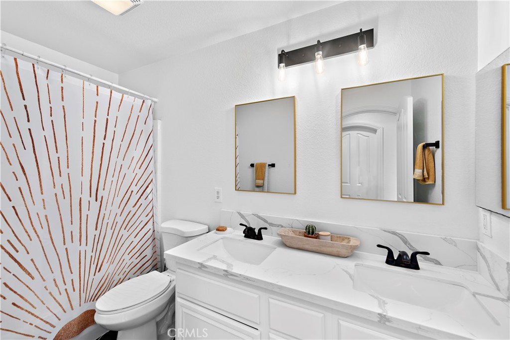 4314 Silver Spring Way Oceanside, CA 92057 - Photo 23 of 47 a bathroom with a sink a toilet and mirror