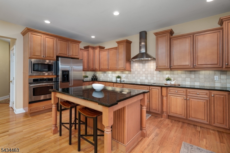 110 Orchard Road Skillman, NJ 08558 - Photo 10 of 43 a kitchen with kitchen island granite countertop wooden cabinets and a stove