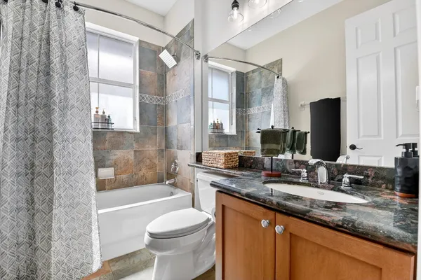 a bathroom with a granite countertop sink toilet and shower