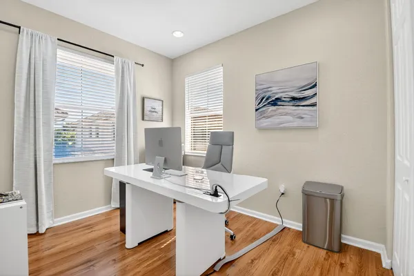 a view of a workspace with furniture and wooden floor