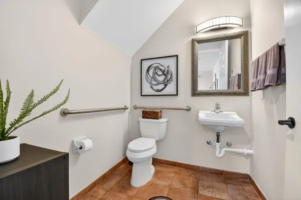 a bathroom with a toilet a sink and mirror