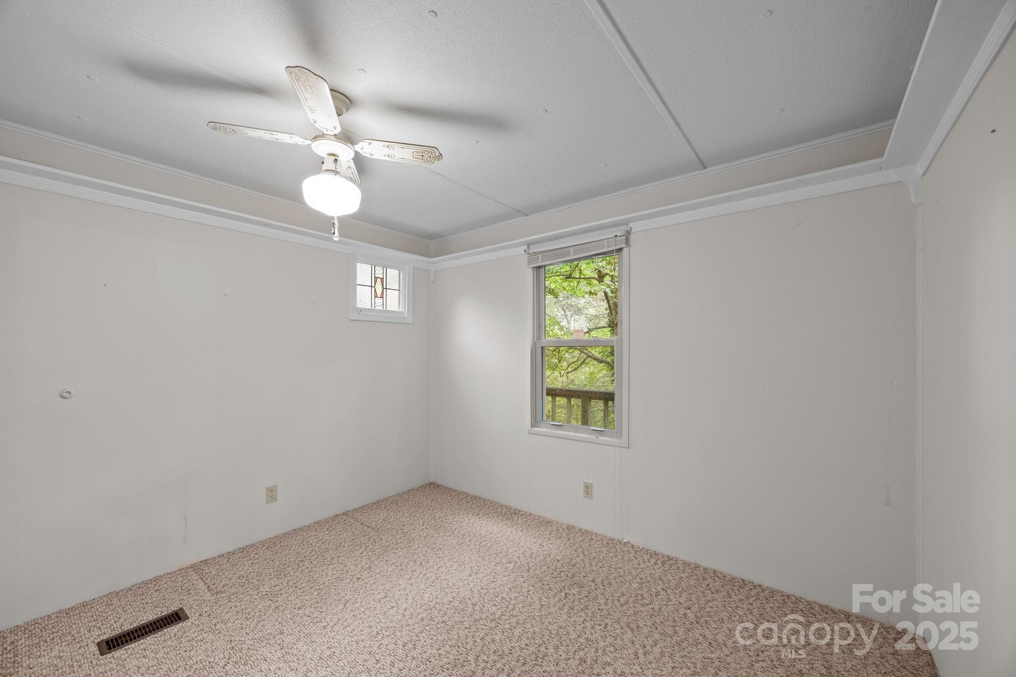 101 Serenity Lane Clyde, NC 28721 - Photo 22 of 26 an empty room with a window and ceiling fan