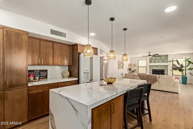 a kitchen with a refrigerator a stove and a dining table with wooden floor