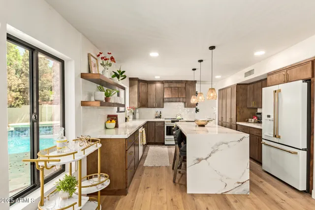 an empty room with wooden floor ceiling fan and windows