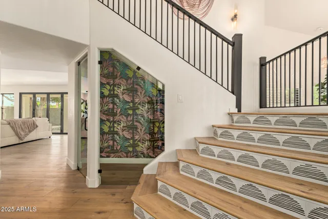 a view of a hallway with wooden floor and a bathroom