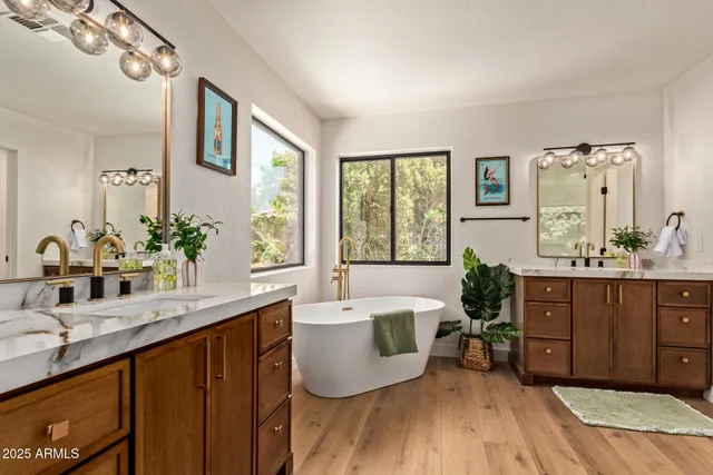 a bathroom with a tub a sink and a window