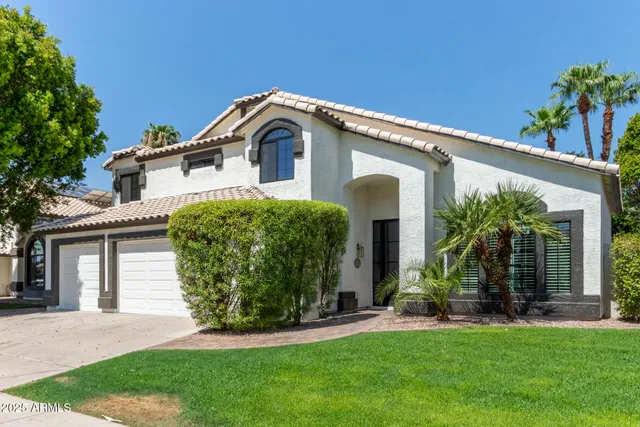 a front view of a house with a garden and plants