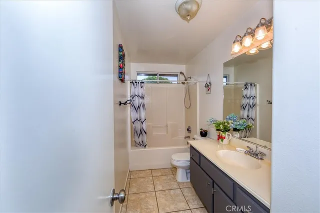 a bathroom with a granite countertop sink a toilet and shower
